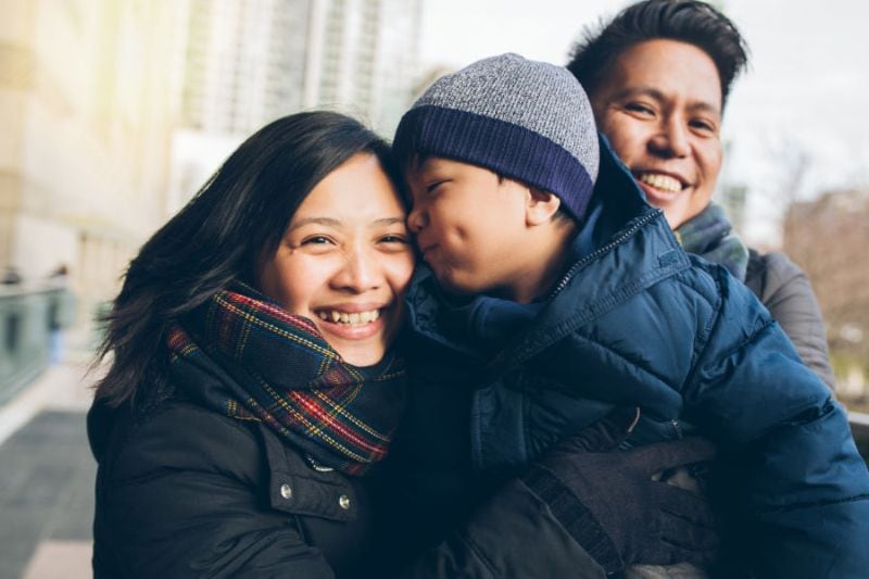 Is Your Heating System Ready for This Winter? - Family Bundled up in Winter Clothes smiling outdoors.